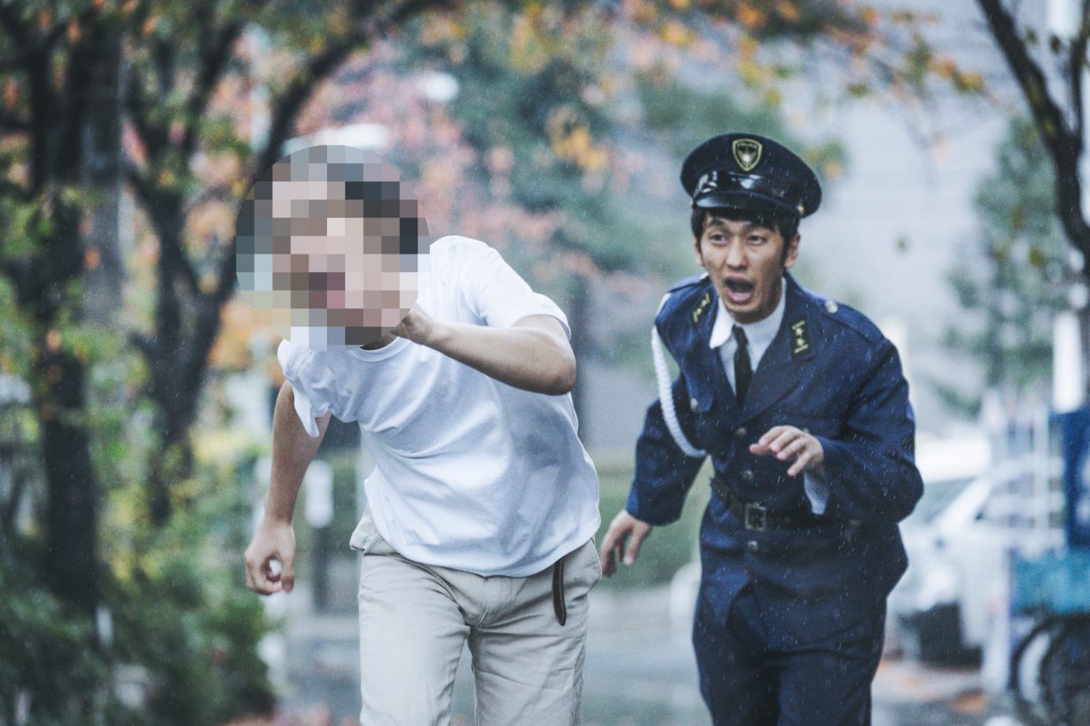 逃げる男性を追いかける警察官の画像